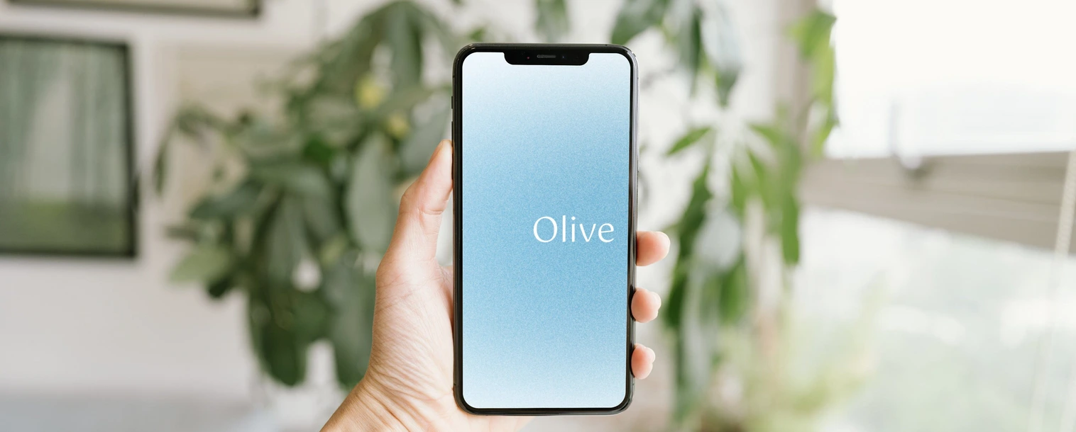 Olive app splash screen shown on a phone held in a hand